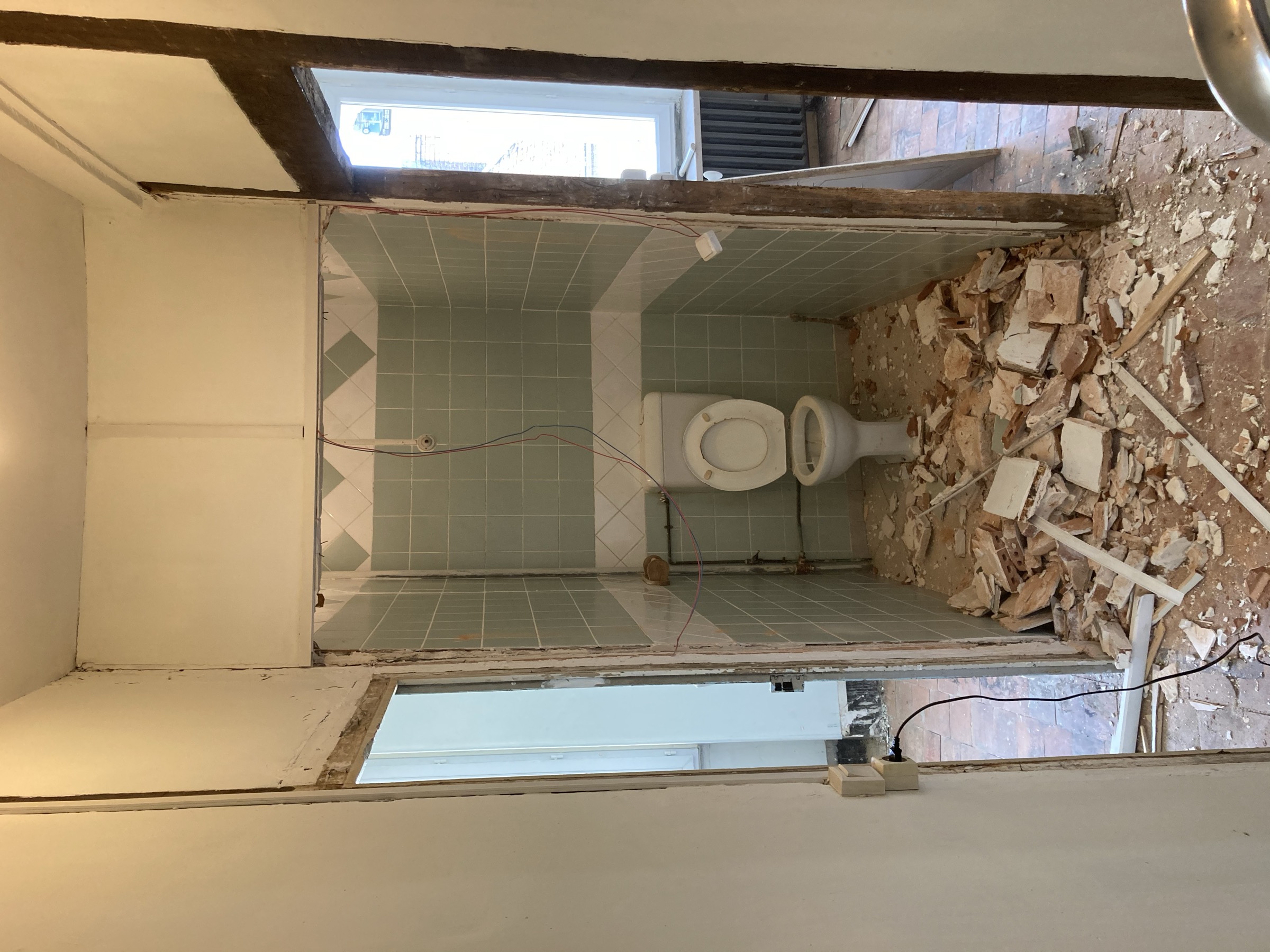 Anciens WC en cours de démolition, gravats au sol